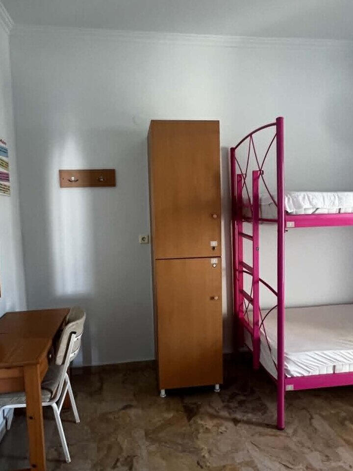 Bright pink-bed dorm Bright dorm room with pink bunk beds, desk and guest lockers at Youth Hostel Anna